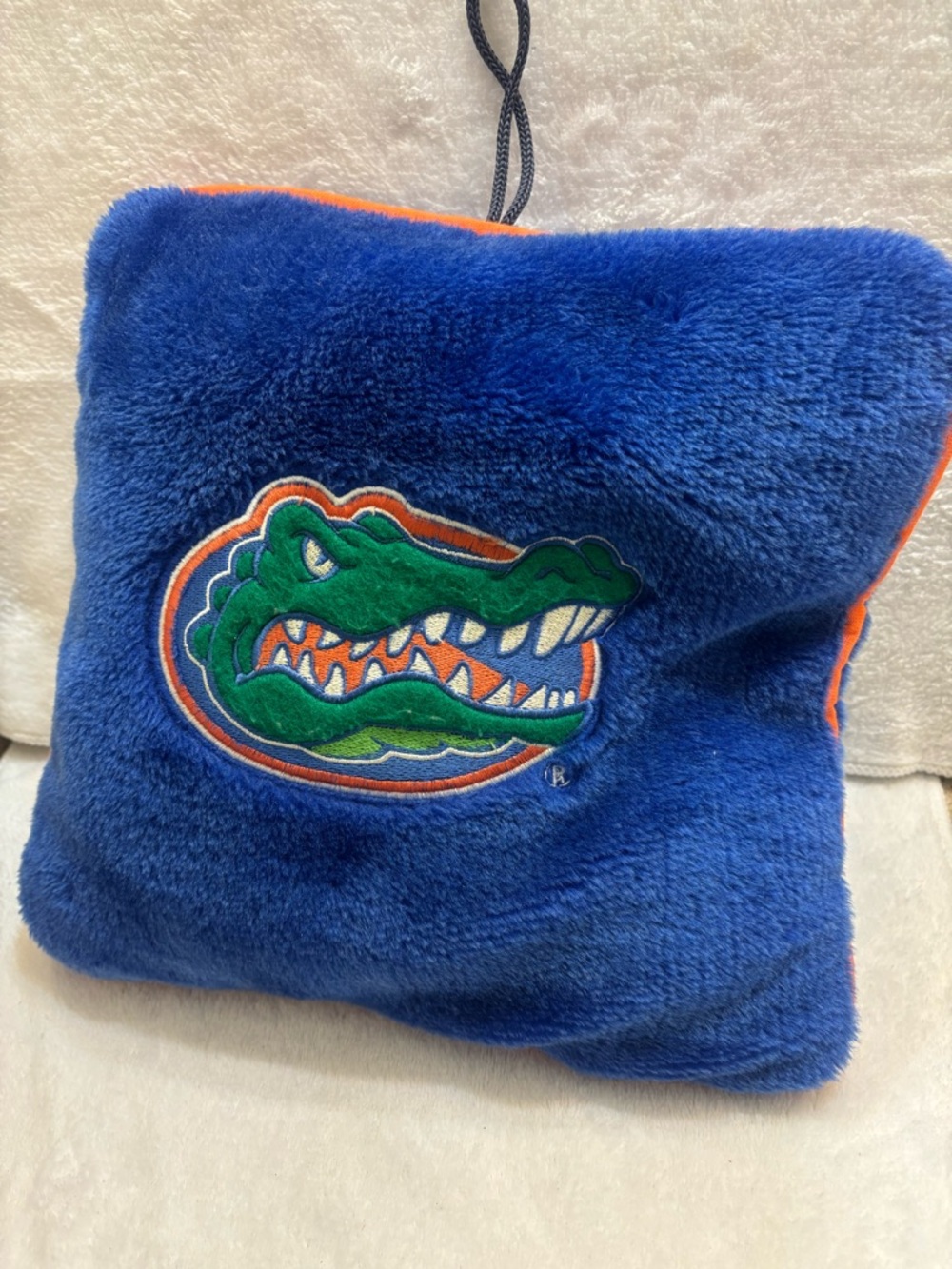 Plush Florida Gators fleece pillow decorated with the team logo. 13”x12”